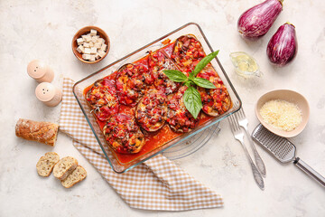 Dish of tasty baked vegetables on light background