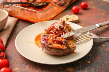 Plate of tasty baked vegetables on grunge background