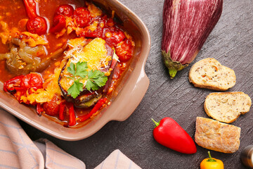 Dish of tasty baked vegetables on dark background