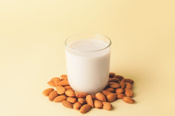 Glass of tasty almond milk on color background