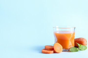 Glass of healthy smoothie with carrot on color background