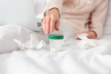 Sick young woman taking pills at home