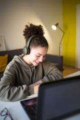 happy mixed rase girl sits at computer screen laptop. student talks over Internet. Video Conference...