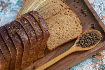 Slices of brown bread with pepper on a wooden board
