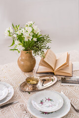 Vintage vase with flowers on table. Vintage ware. Old book. Isolated