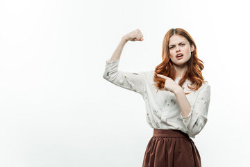 red-haired woman in a suit gesturing with her hands light background