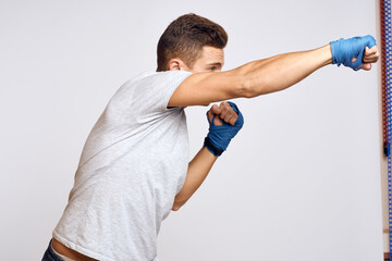 Sportive man boxing bandages on workout hands in gym exercises