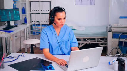 Healthcare physician prescribing prescriptions for patients during telehealth using headset,...
