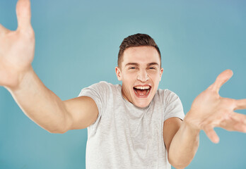 funny emotional man white t-shirt hand gestures closeup blue background