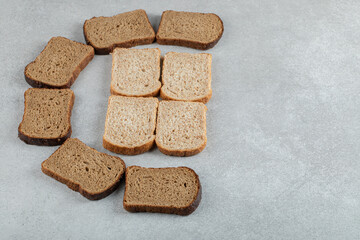 Many of slices of brown bread on a gray background