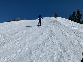 Arbeser mit Gipfelkreuz beim Skigebiet Kellerjoch am Hecher Pillberg  in der Nähe von Schwaz Wattens Innsbruck in Tirol, gegenüber das Karwendel Gebirge im Winter  mit Schneeschuhen oder Tourenski