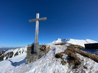 Arbeser mit Gipfelkreuz beim Skigebiet Kellerjoch am Hecher Pillberg  in der Nähe von Schwaz Wattens Innsbruck in Tirol, gegenüber das Karwendel Gebirge im Winter  mit Schneeschuhen oder Tourenski
