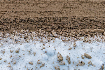 Automobile road in winter. Dirty snow on the road and its side.
