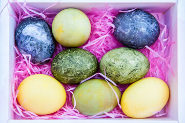 Easter colored eggs in white box with pink ribbons