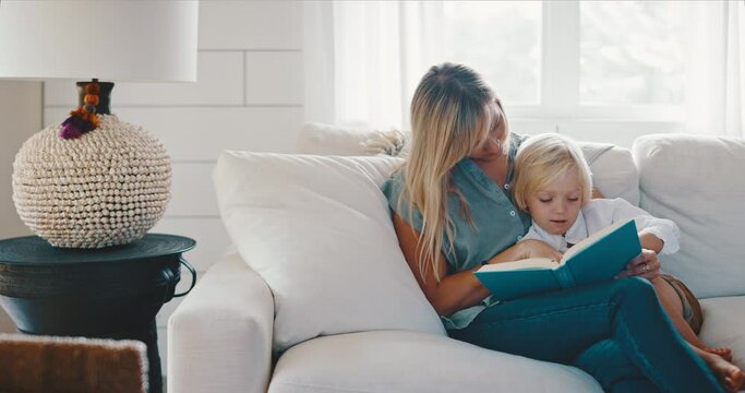 Young mother and son reading together at home on the couch, quality family time, teachable moments, family lifestyle