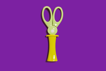 scissors with a cap on a purple surface