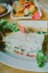 A club sandwich on a rustic table in bright lighte 