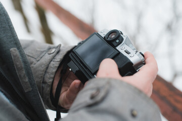 Close-up of a man using a camera. Photographer outside in winter. Selective focus