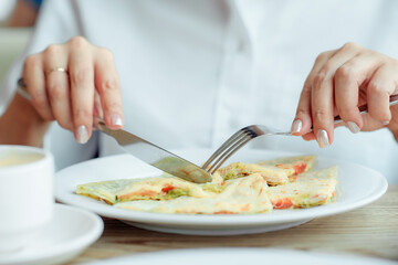 knife and fork in the hands of a girl during breakfast