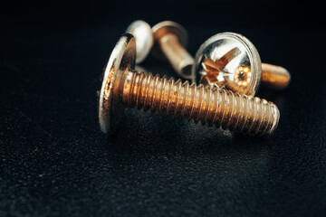 Iron screw bolts on black background close up