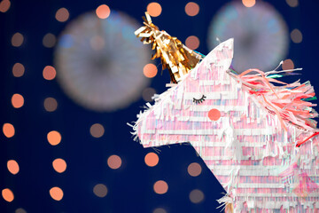 Unicorn party pinata on blue bokeh background