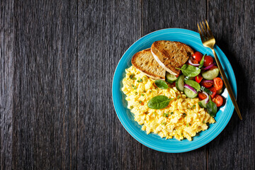 scrambled eggs with veggies and bread on a plate