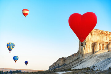 Red heart-shaped air balloon flying in the sky
