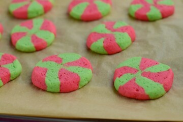 Homemade colorful Christmas cookies in the form of green and red pinwheels on baking sheet
