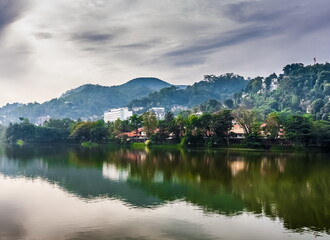Fototapeta na wymiar View of the city pond against the overcast sky of Kandy in Sri Lanka