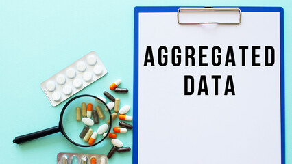 A clipboard with paper lies on a table near drugs and a syringe. Inscription AGGREGATED DATA.