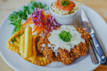 Fried pork chop, French fries and vegetables