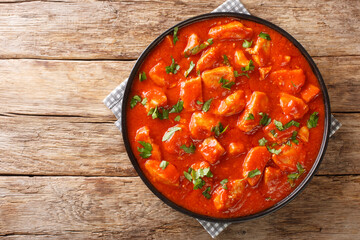 Romanian Ostropel Chicken with Garlicky Tomato Gravy closeup in the plate on the table. Horizontal top view above