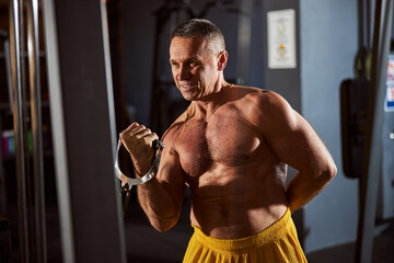 Fototapeta premium Enthusiastic male athlete working out at his regular gym