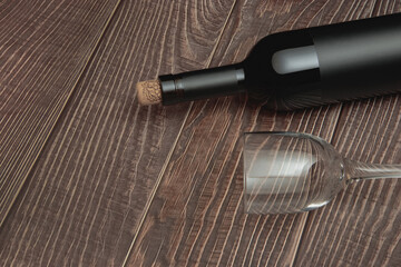 Naklejka premium Wine glass and collectible bottle of wine on wooden background with old texture