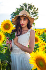 Summer look. Beautiful girl in sunflower fields.