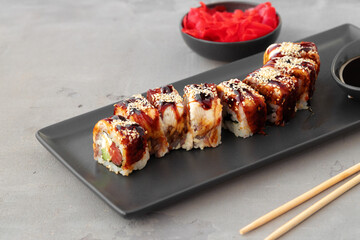 Dragon sushi roll with eel on black ceramic plate