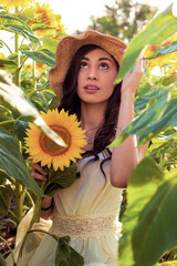 Summer look. Beautiful girl in sunflower fields.