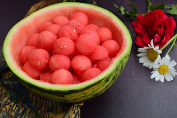 Watermelon balls in a watermelon skin bowl, garnish with daisy flower 