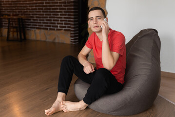 A happy man in living room talking on cell phone