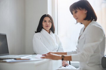 Doctor reading her patient electrocardiogram at the desk