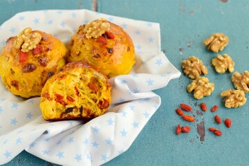 Homemade healthy delicious bread buns with walnut and goji berry . Blue background
