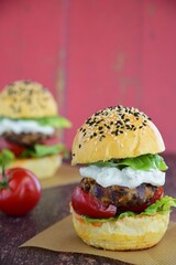 Vegetarian burger. Sesame bread bun with lentil patty, tomato, lettuce and yogurt