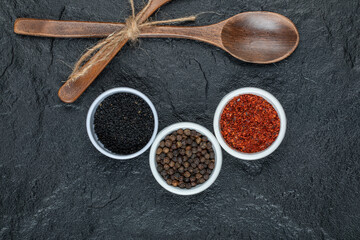 Wooden spoons with spices on a dark background