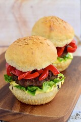 homemade beef burger with red bell peppers, lettuce and curry mayonnaise sauce
