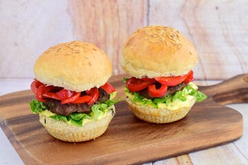 homemade beef burger with red bell peppers, lettuce and curry mayonnaise sauce
