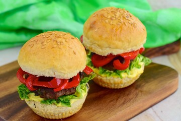 homemade beef burger with red bell peppers, lettuce and curry mayonnaise sauce
