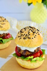Vegetarian burger. Sesame bread bun with lentil patty, tomato, lettuce and yogurt
