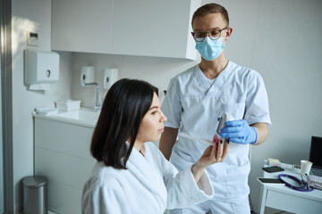 Woman taking a routine spirometry test helped by a physician