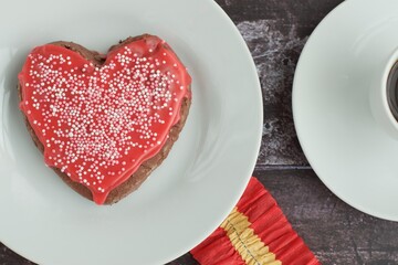 Obraz na płótnie Canvas Heart shaped Valentine's cookie with red sugar glaze and sprinkles