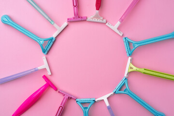Female disposable razors on pink background top view